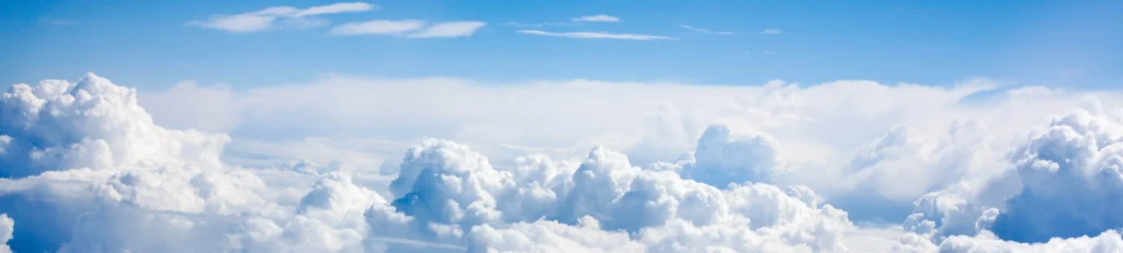 A clear sky view with fluffy white clouds.