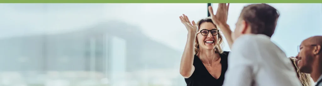 Smiling team members share a high-five